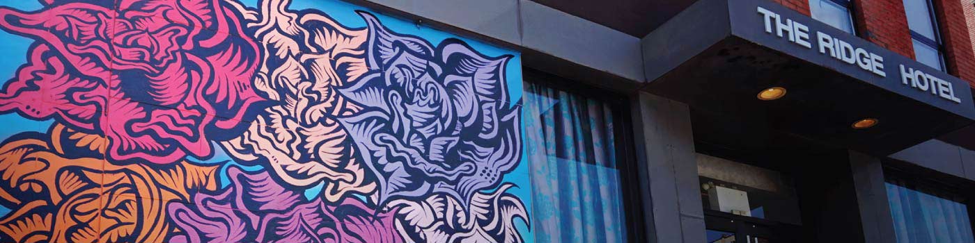 entrance of Ridge Hotel with a colorful mural painted on the wall