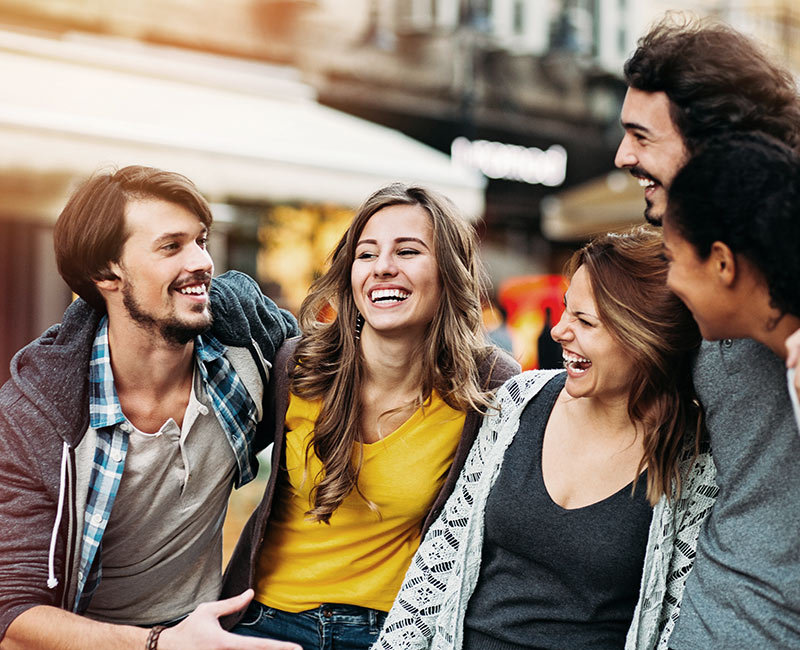 Group of young adults walking down the street laughing