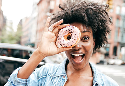 A women smiling and holding a donut