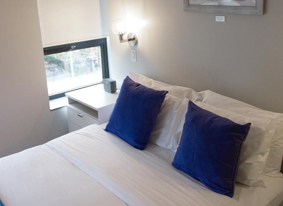 room with queen bed, window and mounted tv