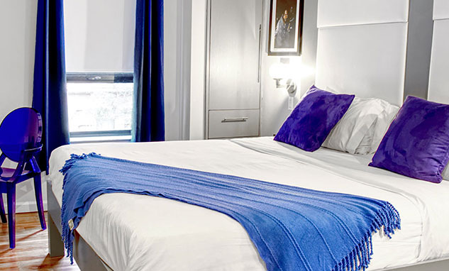 A hotel room with bright blue pillows