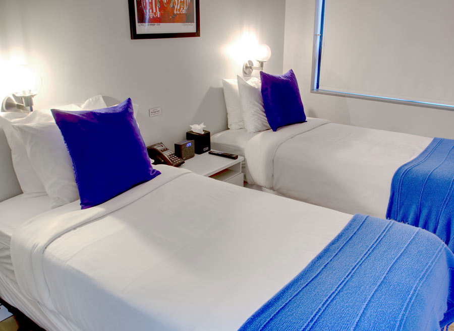 two twin beds side by side with purple pillows